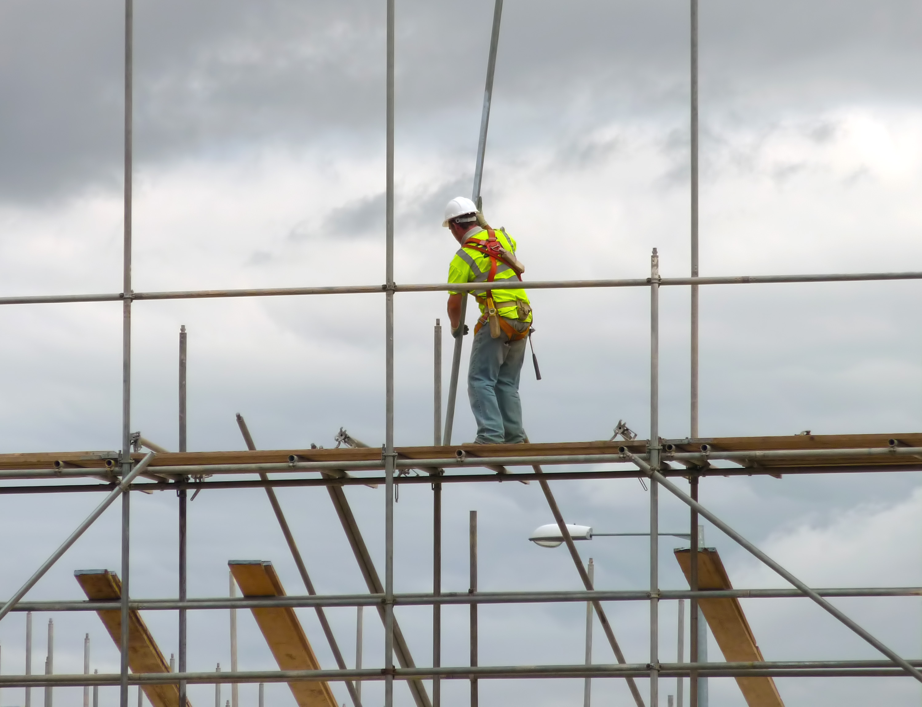 worker avoiding scaffolding hazards on job site