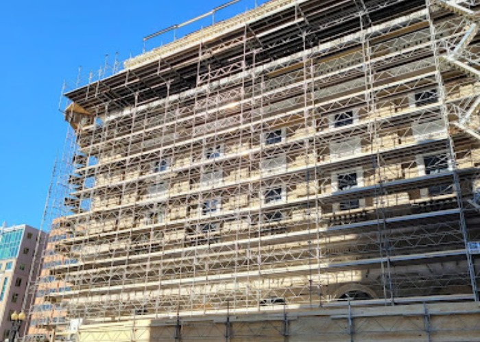 Extensive scaffolding system installed along the exterior of a multi-story building for façade restoration and construction work.