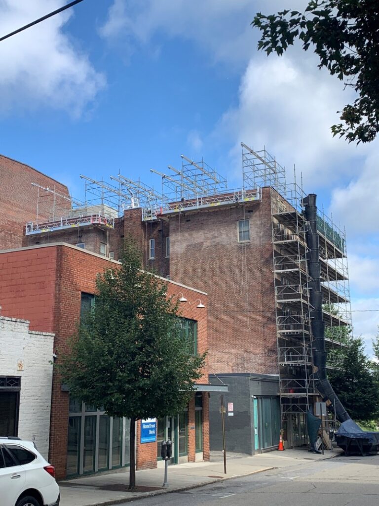 Professional scaffolding system installed on a brick commercial building for exterior maintenance and repair work.